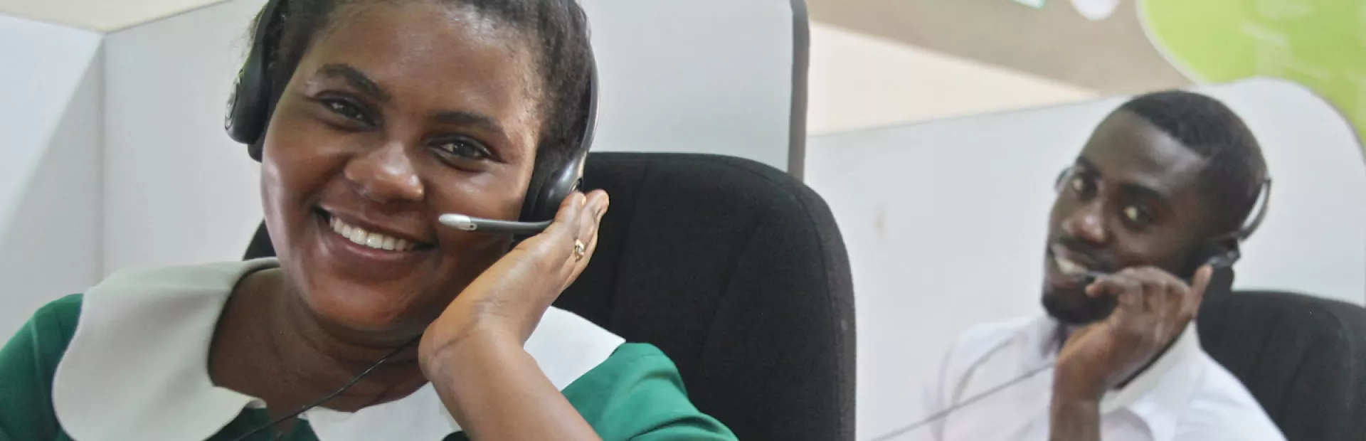 Image showing two telemedicine employees in Ghana with headsets at their workplace