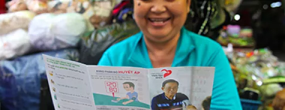 Woman reading in a flyer about blood pressure measurement