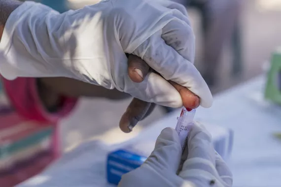 Testing of a child for malaria in Namibia by taking blood from the child's finger tip