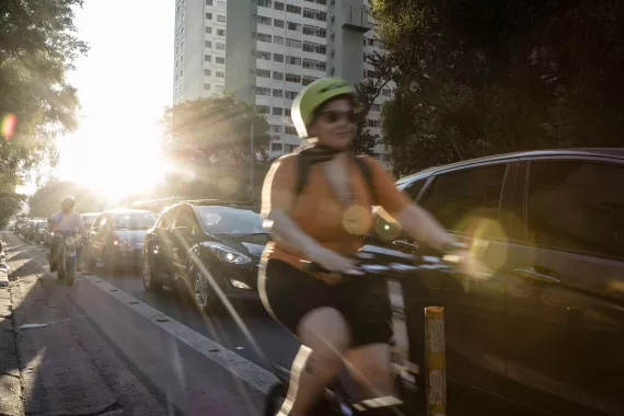Woman cycling on a busy street in Sao Paulo