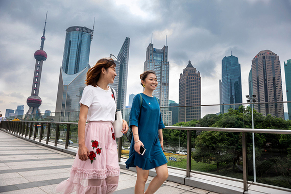 Two ladies walking in a modern city with the skyline in the background