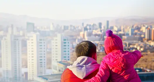 Dad and daughter looking at a city skyline